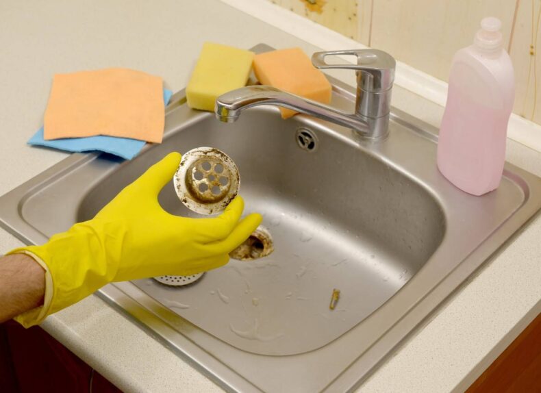 cleaner-in-rubber-gloves-shows-waste-in-the-plugho-2025-03-16-03-19-15-utc (1)