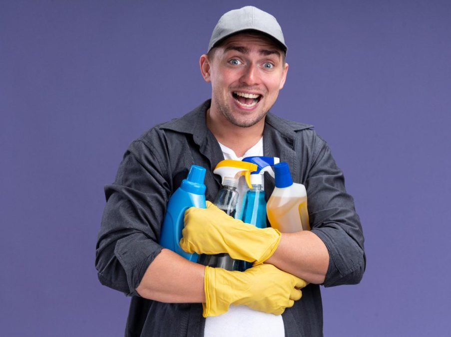 excited-young-handsome-cleaning-guy-wearing-t-shirt-with-cap-gloves-holding-cleaning-tools-isolated-purple-wall-1